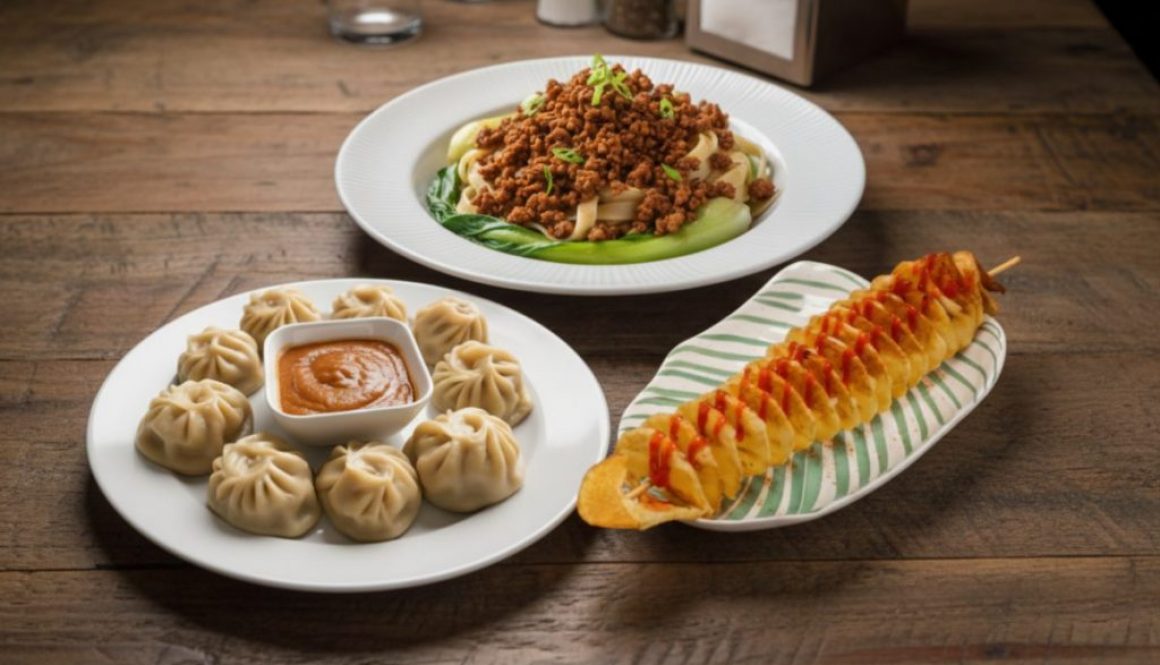 Steamed momo with dipping sauce, keema noodles, and spiral potato